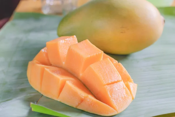 Reife Mango mit Scheiben auf Bananenblättern — Stockfoto