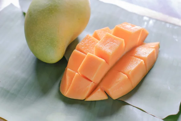 Reife Mango mit Scheiben auf Bananenblättern — Stockfoto