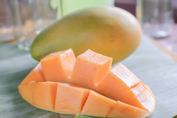 Reife Mango mit Scheiben auf Bananenblättern — Stockfoto