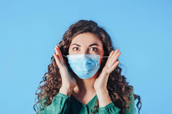 Young beautiful woman in protective mask on blue background. Breathe fresh air. Contaminated air