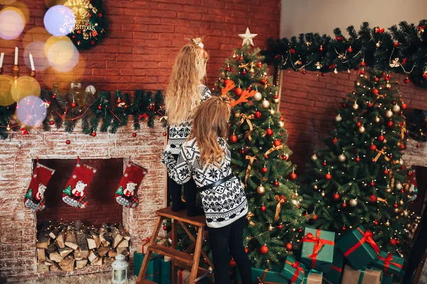 Kinderen Versieren Een Kerstboom Tegen Achtergrond Van Een Bakstenen Muur — Stockfoto