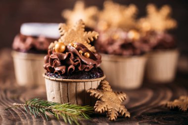 Tahta zemin üzerinde yıldız şeklinde kurabiyeler olan çikolatalı kekler. Noel havası. Herhangi bir durum için şekerler.