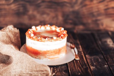 Tahta arka planda çatalla beyaz bir tabakta kek. Her tatil için şeker..