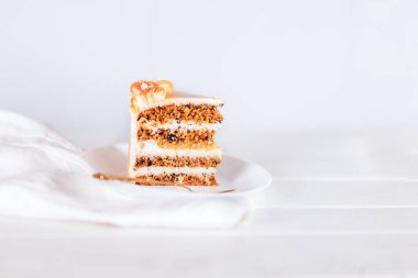 Beyaz bir arka planda beyaz bir tabakta bir dilim kek. Her tatil için şeker..