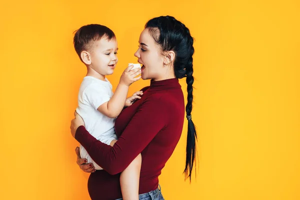 Zwangere Jonge Vrouw Met Een Kleine Baby Voor Een Gele — Stockfoto