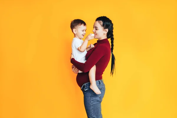 Zwangere Jonge Vrouw Met Een Kleine Baby Voor Een Gele — Stockfoto
