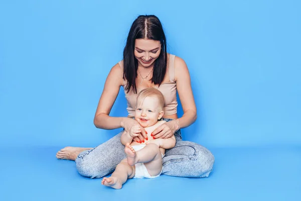 Anne Mavi Bir Arka Planda Oğluyla Kollarında Oynuyor Çocukların Sağlığı — Stok fotoğraf