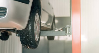 Makine tamir için bir araba asansörüyle kaldırılır. Arabanın yan görüntüsü..