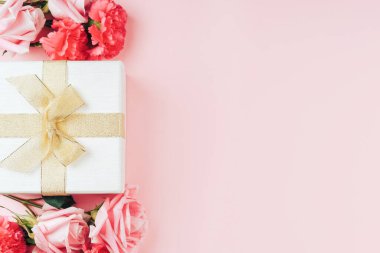 Pembe arka planda hediyeli güzel güller. Metin için boş alan.