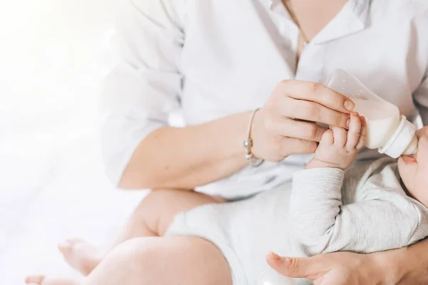 Caring mother bottle feeds her newborn baby. Caring for the health of children. Artificial feeding of children