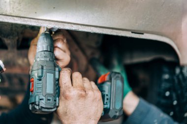 Profesyonel bir tamirci içten yanmalı motoru tamir eder ve yağı değiştirir. Benzin istasyonu çalışanı