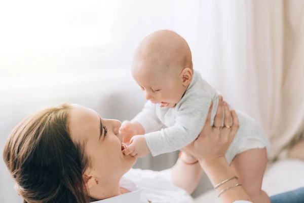 Mãe gentil segurando seu bebê em seus braços. Cuidar da saúde das crianças — Fotografia de Stock