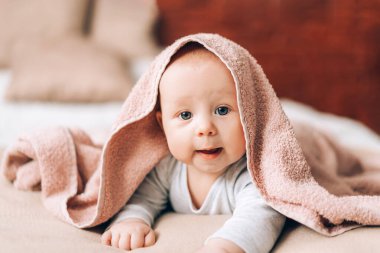 Karnının üstünde ve havluyla kaplı güzel bir bebek. Çocukların sağlığıyla ilgilenmek.
