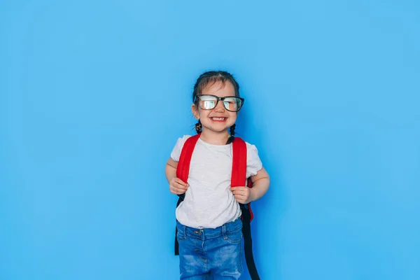Azjatka Okularach Czerwonym Plecakiem Przed Niebieskim Tłem Powrót Szkoły 2021 — Zdjęcie stockowe