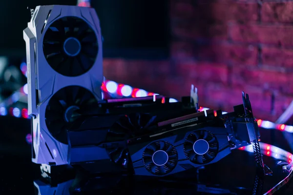 Neon ışığı altında siyah masanın üzerinde farklı boyutlarda ve yapılandırılmış grafikler. Oyun ve kripto para birimi madenciliği için bilgisayarın bir parçası.