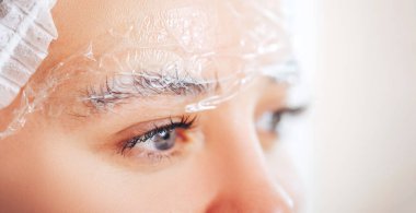 Uzman kozmetik uzmanı kalıcı makyaj işleminden önce anestezi ve ağrı kesici yapıyor..