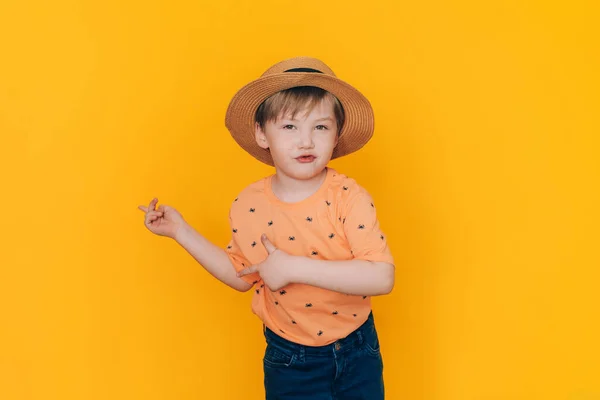 Αγόρι Ψάθινο Καπέλο Δείχνει Χέρια Απέναντι Από Κίτρινο Φόντο Copyspace — Φωτογραφία Αρχείου