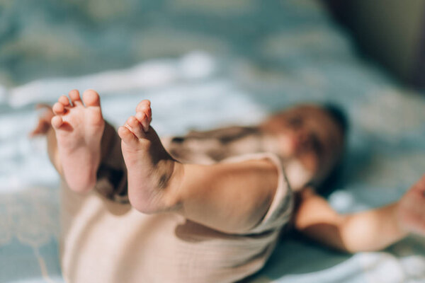 Усыновление ребенка и экстракорпоральное оплодотворение. Азиатский ребенок лежит на кровати. Уход за новорожденными детьми.