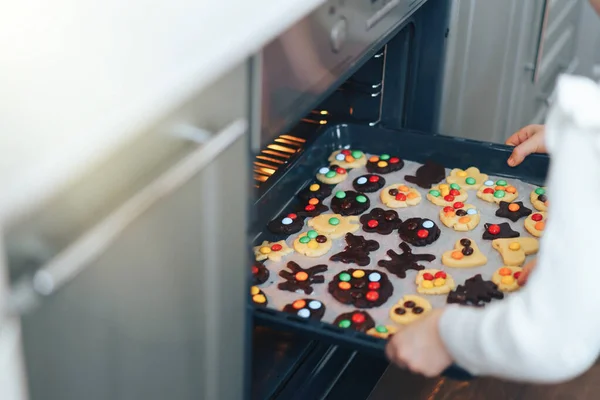 Kinder legen Plätzchen auf Backblech in den Ofen — Stockfoto