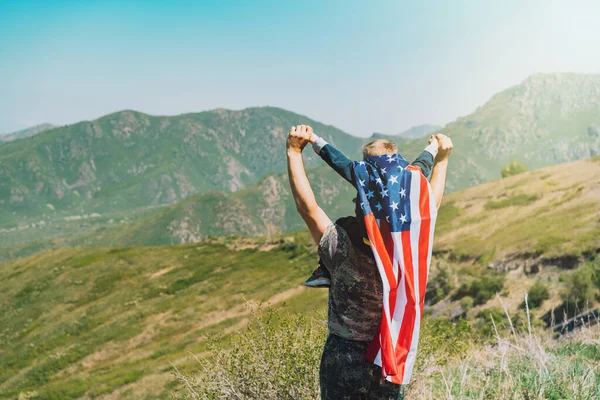 Man Med Barn Halsen Pojke Ryggen Har Amerikansk Flagga Bakgrunden — Stockfoto