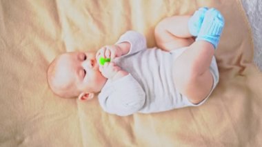 Yeni doğmuş bebek emziğiyle oynuyor.