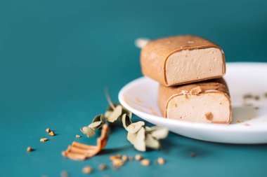 Çikolatalı buzlu şekerler birbirinin üzerine konmuş ve beyaz tabaklar arka planda.