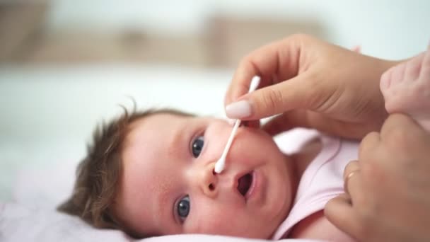 Newborn baby cleaning the nose with a cotton swab — 图库视频影像