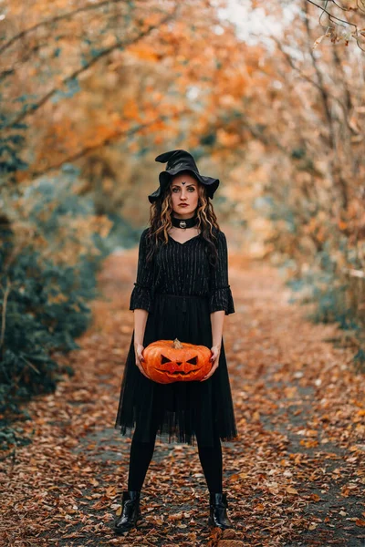 Elinde Balkabağı Tutan Cadı Kostümlü Bir Kızla Dikey Fotoğraf — Stok fotoğraf