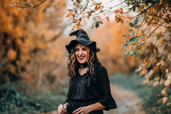 Cadı Gibi Giyinmiş Bir Kız Ormanın Arka Planında Gülüyor — Stok fotoğraf