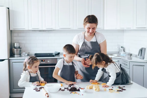 Kinder helfen Mama beim Plätzchenbacken. Freizeitaktivitäten mit Kindern — Stockfoto