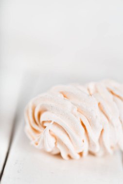 Tahta bir masada iştah açıcı beyaz marşmelov. Çay içme konsepti. Şekerleme dekorasyonu. Metin için yer.