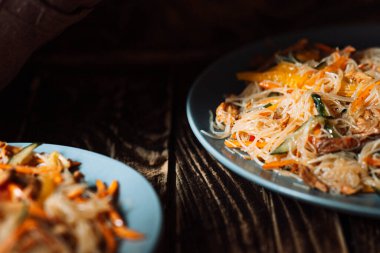 İki mavi tabak ve ahşap arka planda salata..