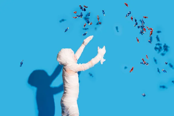 Mumya Kostümlü Çocuk Mavi Arka Planda Şeker Yakalıyor Cadılar Bayramı — Stok fotoğraf