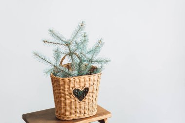 Noel ağacının dalları hasır sepetin içinde tahta merdiven üzerinde.