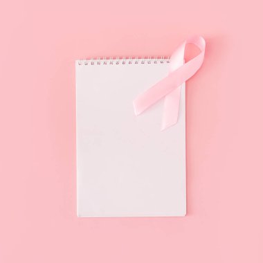 Pembe arka plandaki beyaz not defterine pembe kurdele..