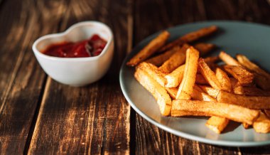 Patates kızartması mavi tabakta, sosun yanında..