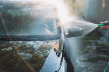 Makinenin üzerine su dökülen hortumu tut..