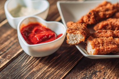 Tavuklu nugget tabakta, sosun yanında.