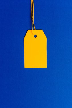 Mavi arkaplanda sarı fiyat etiketi minimum üst görünümde. Yüksek kalite fotoğraf
