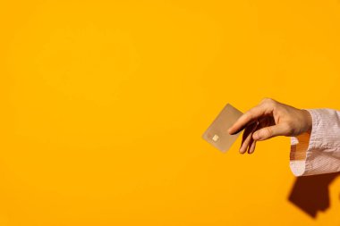 Sarı arka planda bej, temas olmayan bir kredi kartı var. Yüksek kalite fotoğraf