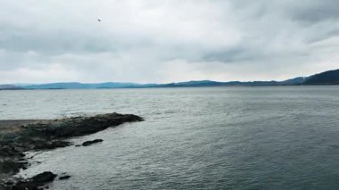 Kaya kıyı şeridi ve dalgalarla kaplanmış geniş bir deniz manzarası. Yüksek kalite 4k görüntü