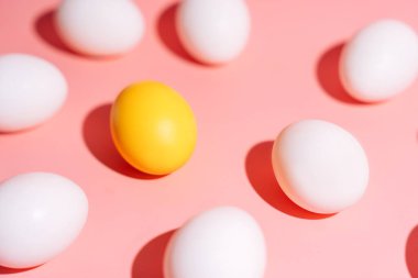 Asgari Paskalya yumurtası desenli, pembe üzerine beyaz yumurtalar arasında bir sarı yumurta. Yüksek kalite fotoğraf