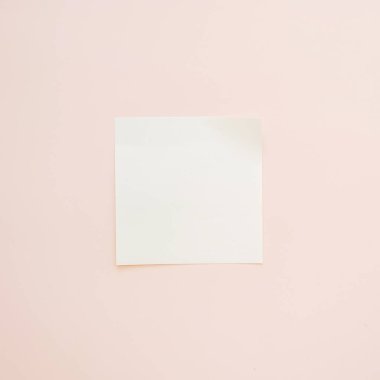 Pastel pembe arkaplanda kopya alanı olan boş yapışkan bir not.