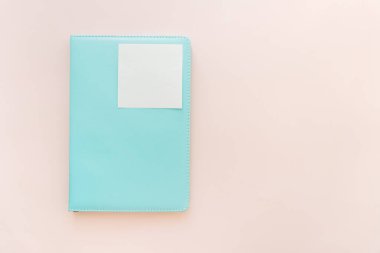 Yumuşak pastel arka plan üzerinde boş yapışkan notla bir turkuaz üst görünüm, planlama ve yapmak için konsept, boşluk kopyalama.