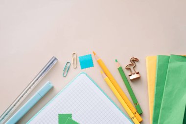 Pastel masanın üzerine not defteri, kalem ve kağıt ile yapıştırma ve günlük malzemeleri, geniş kopya alanı.