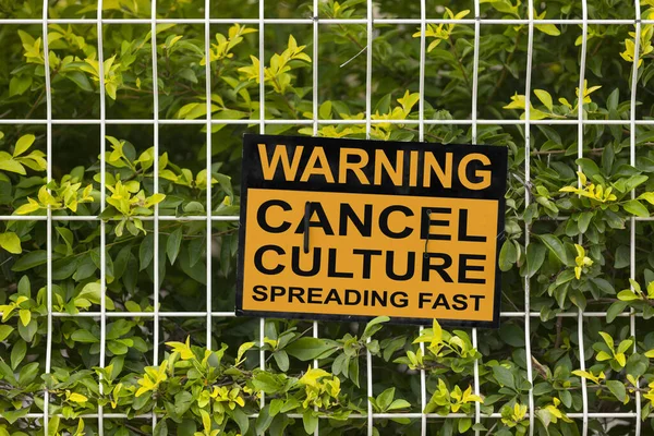 Black and yellow warning sign on a fence stating \