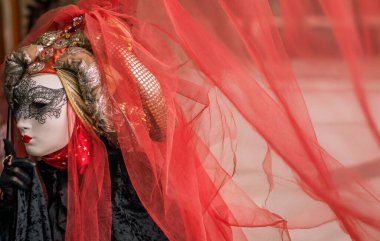 Büyüleyici bir kostüm ve çok zarif kırmızı peçeli bir maske.