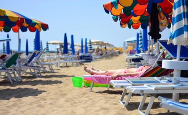 Yazın kumsalda güneşlenirler.