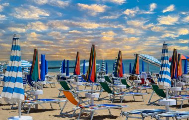 Şemsiyeler ve şezlonglar yazın başlangıcı için sahili boyuyorlar.