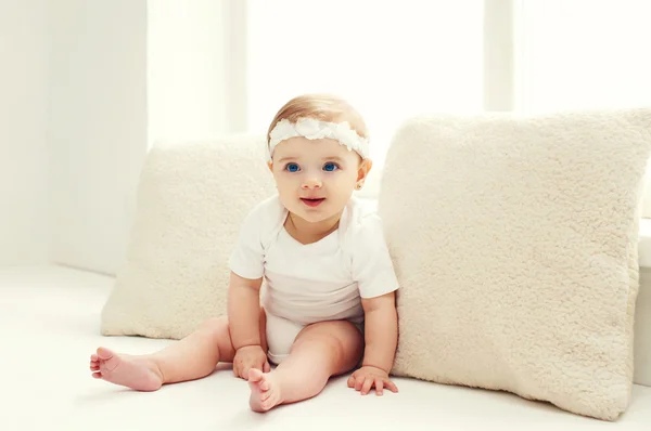 Eve pencere yakınındaki beyaz odada oturan şirin bebek — Stok fotoğraf